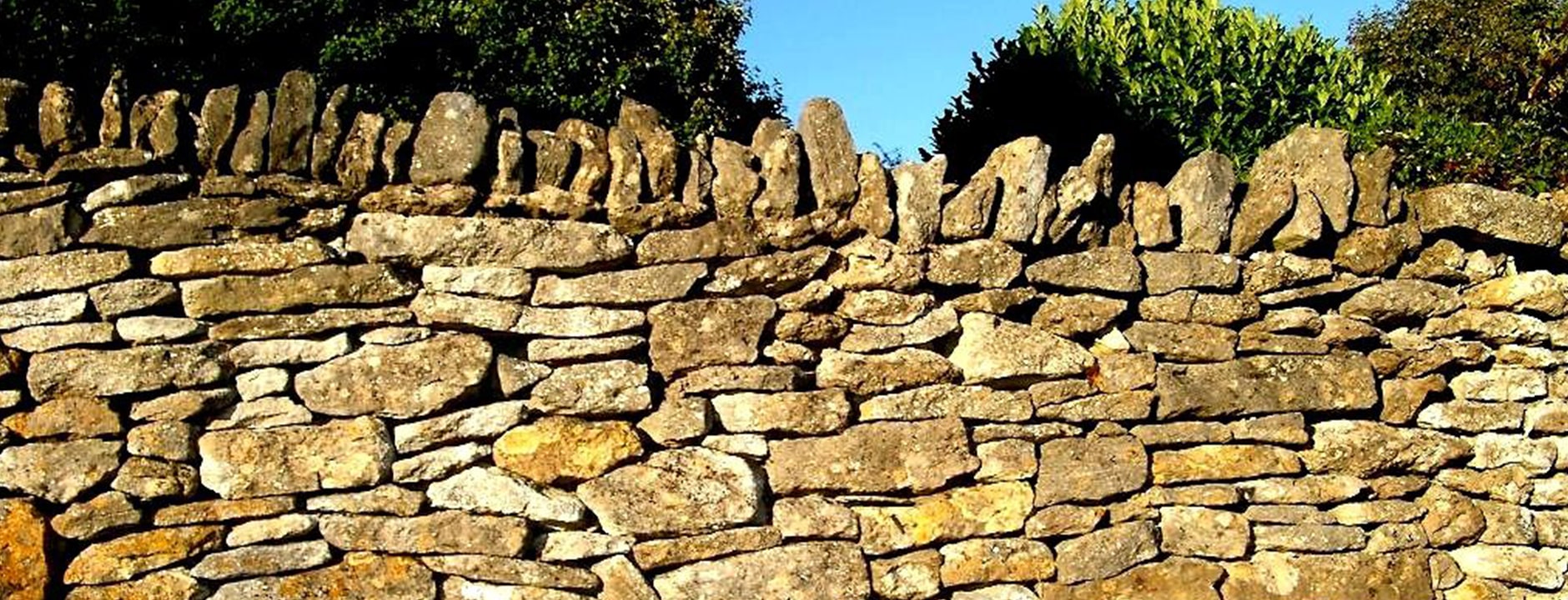 A dry stone wall with blue sky above